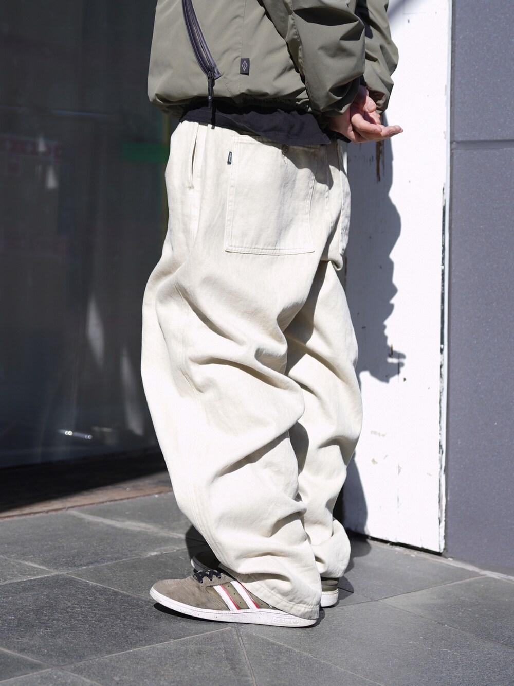 グリーン系のブルゾン、ベージュ系のその他パンツ、ホワイト系のハットを着用したメンズの冬コーディネートの9枚目の写真