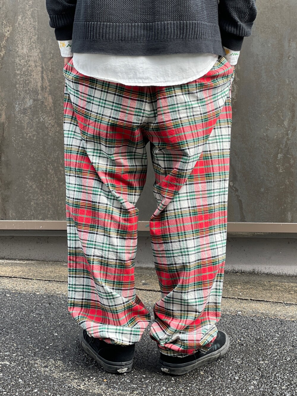 ブラック系のニット/セーター、レッド系のその他パンツ、ホワイト系のシャツ/ブラウスを着用したメンズの春コーディネートの8枚目の写真