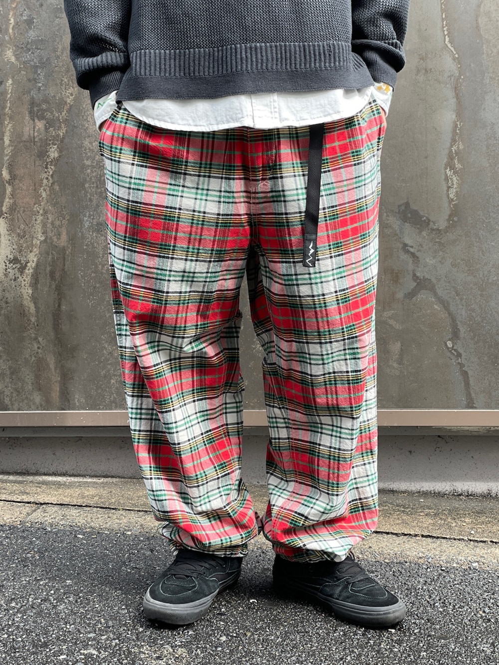 ブラック系のニット/セーター、レッド系のその他パンツ、ホワイト系のシャツ/ブラウスを着用したメンズの春コーディネートの6枚目の写真