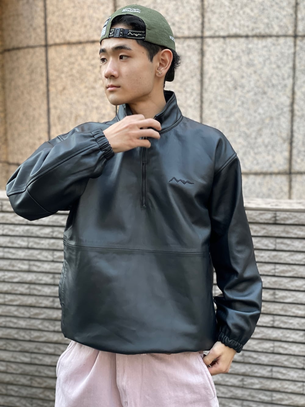 ブラック系のブルゾン、ピンク系のパンツを着用したメンズの冬コーディネートの3枚目の写真