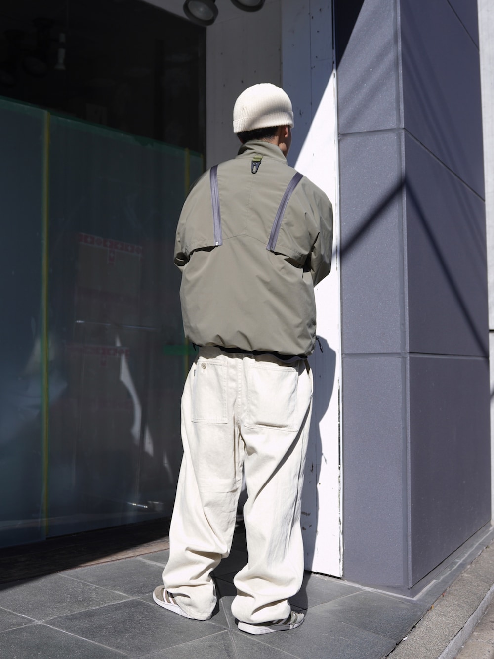 グリーン系のブルゾン、ベージュ系のその他パンツ、ホワイト系のハットを着用したメンズの冬コーディネートの3枚目の写真