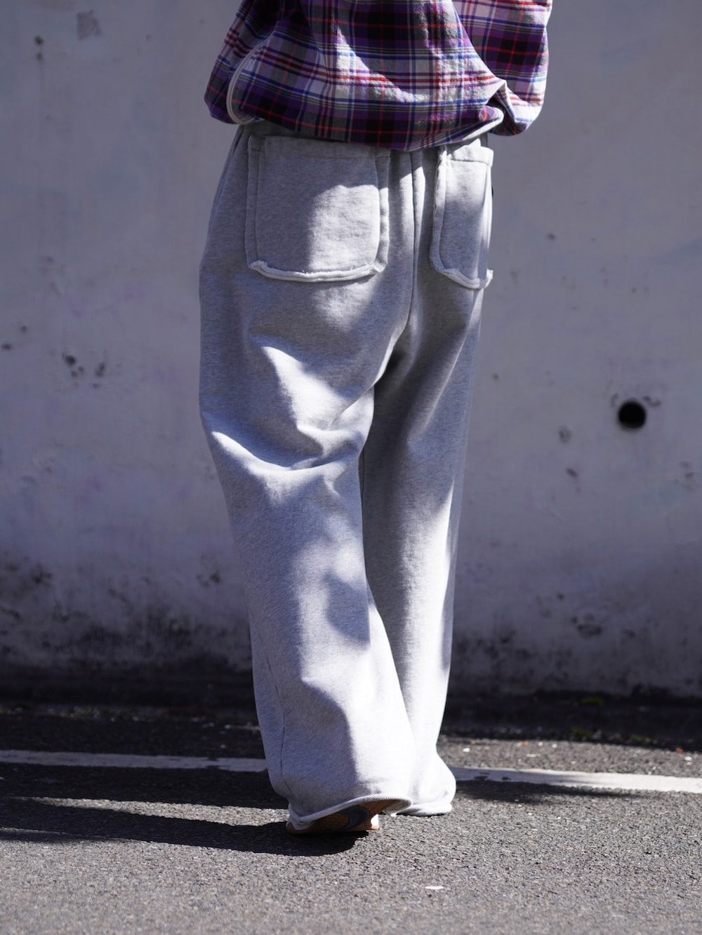 パープル系のブルゾン、グレー系のスウェットパンツを着用したメンズの冬コーディネートの8枚目の写真