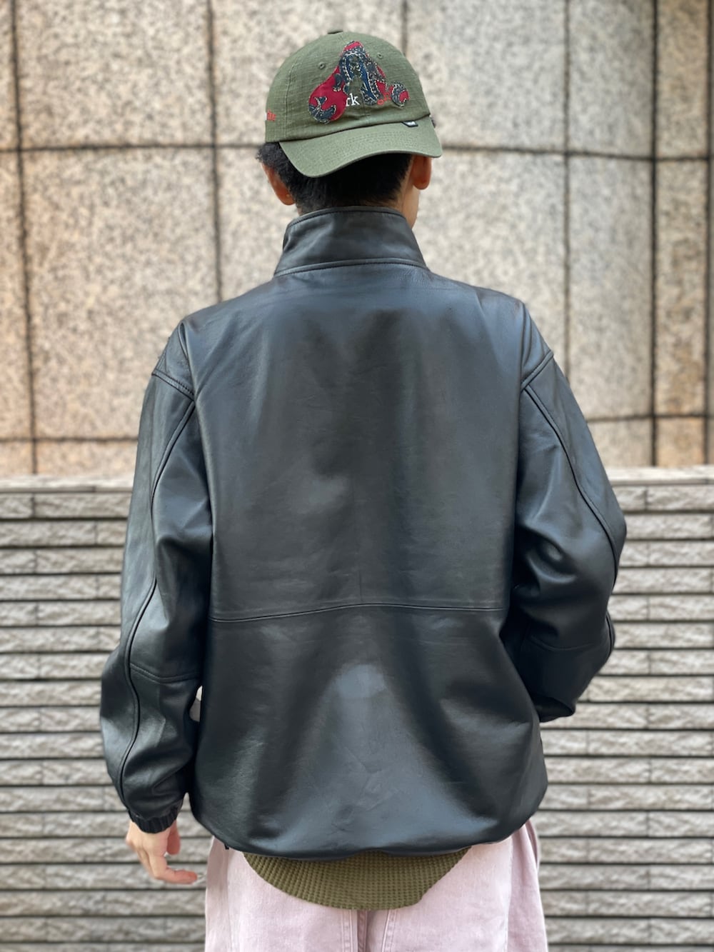 ブラック系のブルゾン、ピンク系のパンツを着用したメンズの冬コーディネートの4枚目の写真