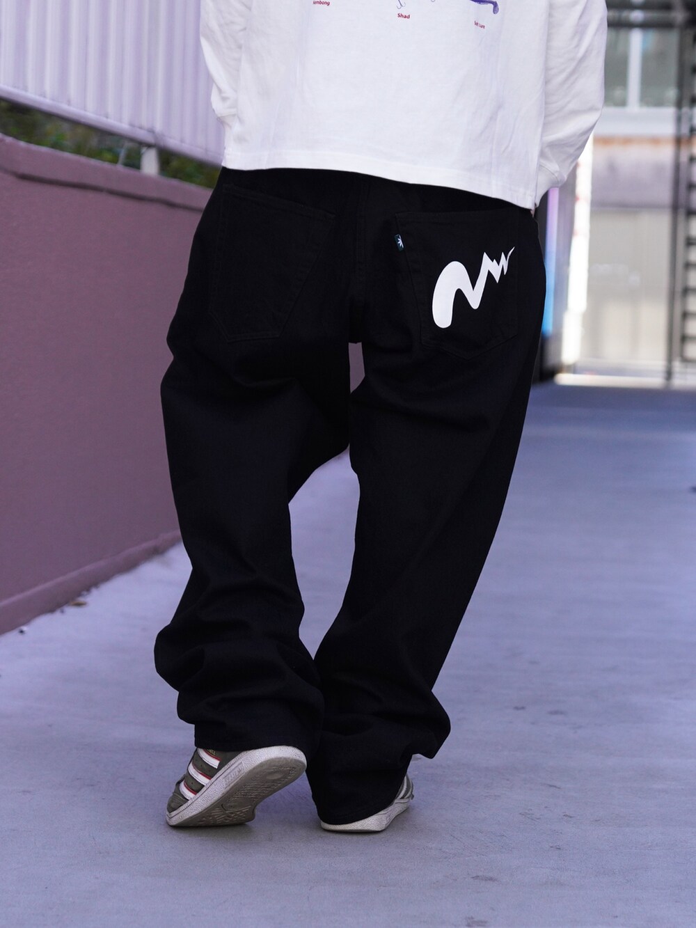 ホワイト系のTシャツ/カットソー、ブラック系のデニムパンツ、グリーン系のニットキャップ/ビーニーを着用したメンズの冬コーディネートの5枚目の写真