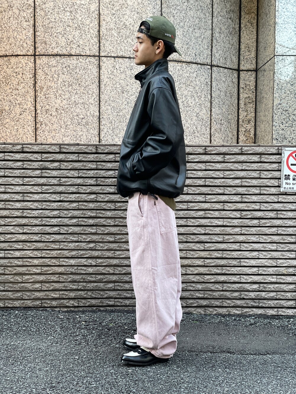 ブラック系のブルゾン、ピンク系のパンツを着用したメンズの冬コーディネートの2枚目の写真