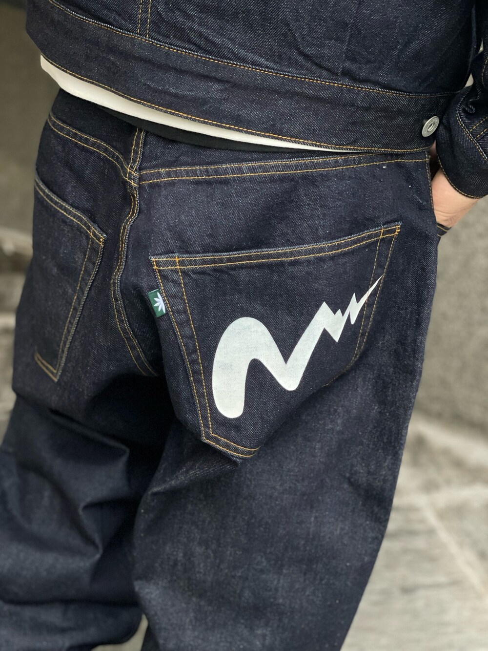 ホワイト系のパーカー、ブルー系のデニムパンツを着用したメンズの冬コーディネートの8枚目の写真
