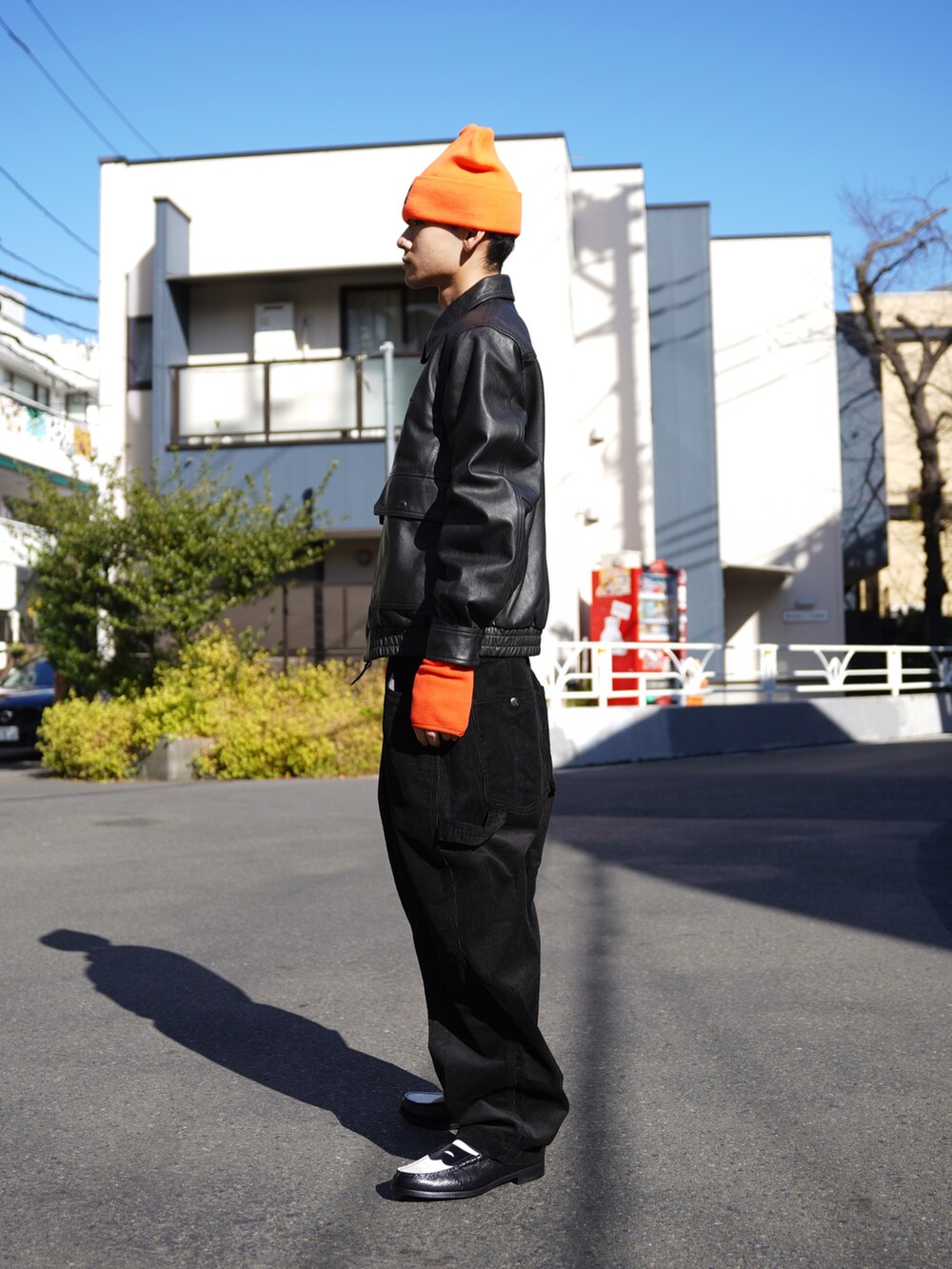 ブラック系のブルゾン、ブラック系のその他パンツ、オレンジ系の手袋を着用したメンズの冬コーディネートの2枚目の写真