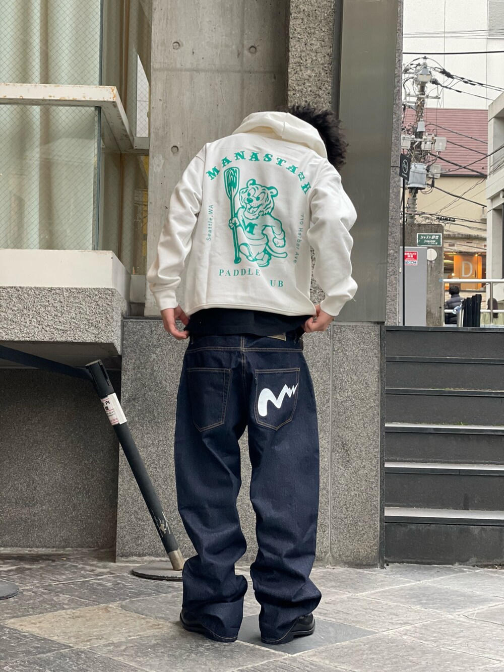ホワイト系のパーカー、ブルー系のデニムパンツを着用したメンズの冬コーディネートの3枚目の写真