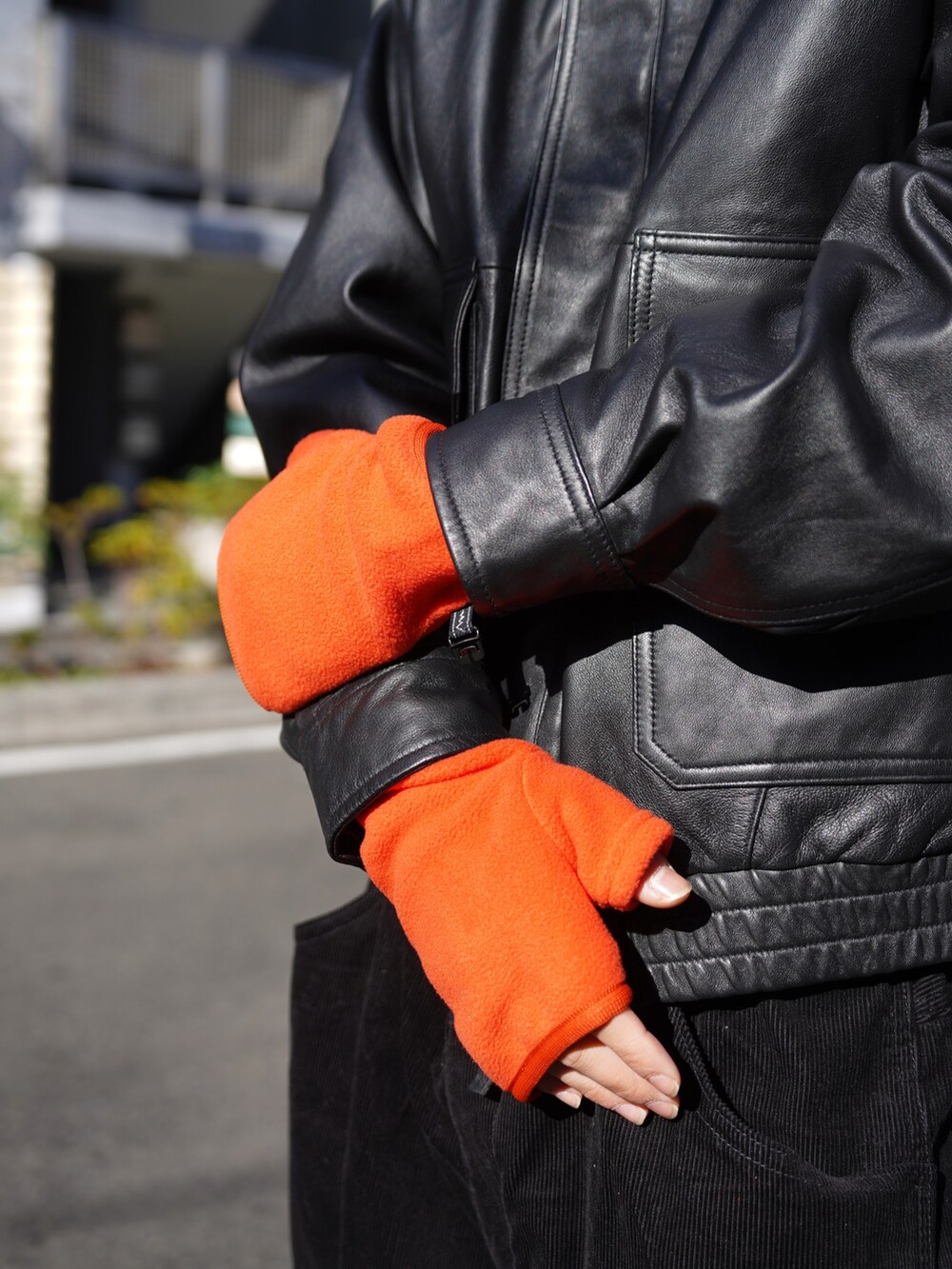 ブラック系のブルゾン、ブラック系のその他パンツ、オレンジ系の手袋を着用したメンズの冬コーディネートの8枚目の写真