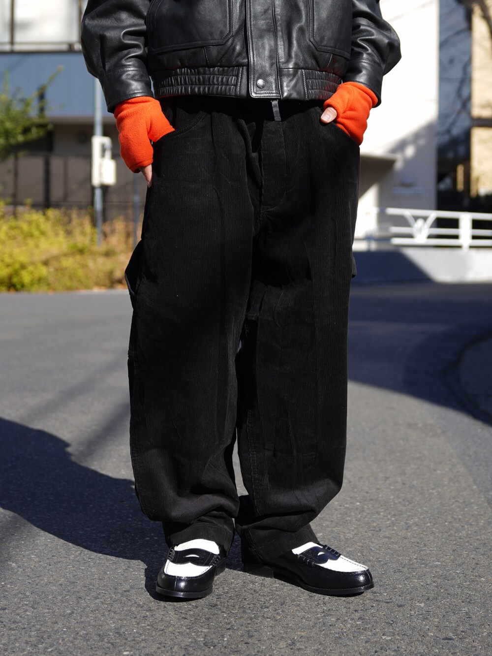 ブラック系のブルゾン、ブラック系のその他パンツ、オレンジ系の手袋を着用したメンズの冬コーディネートの5枚目の写真