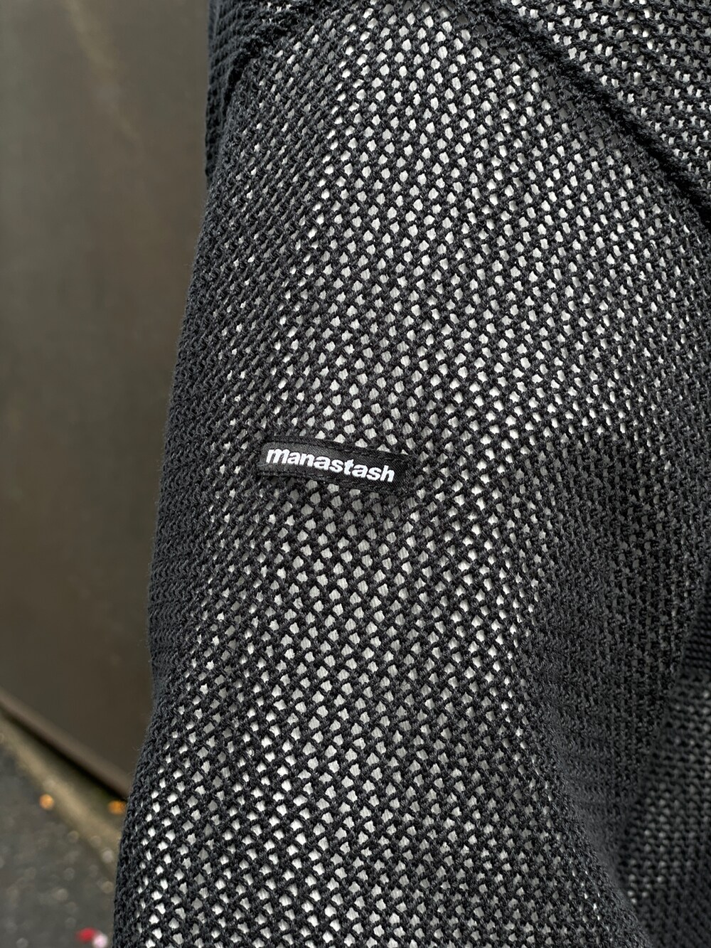 ブラック系のニット/セーター、レッド系のその他パンツ、ホワイト系のシャツ/ブラウスを着用したメンズの春コーディネートの5枚目の写真