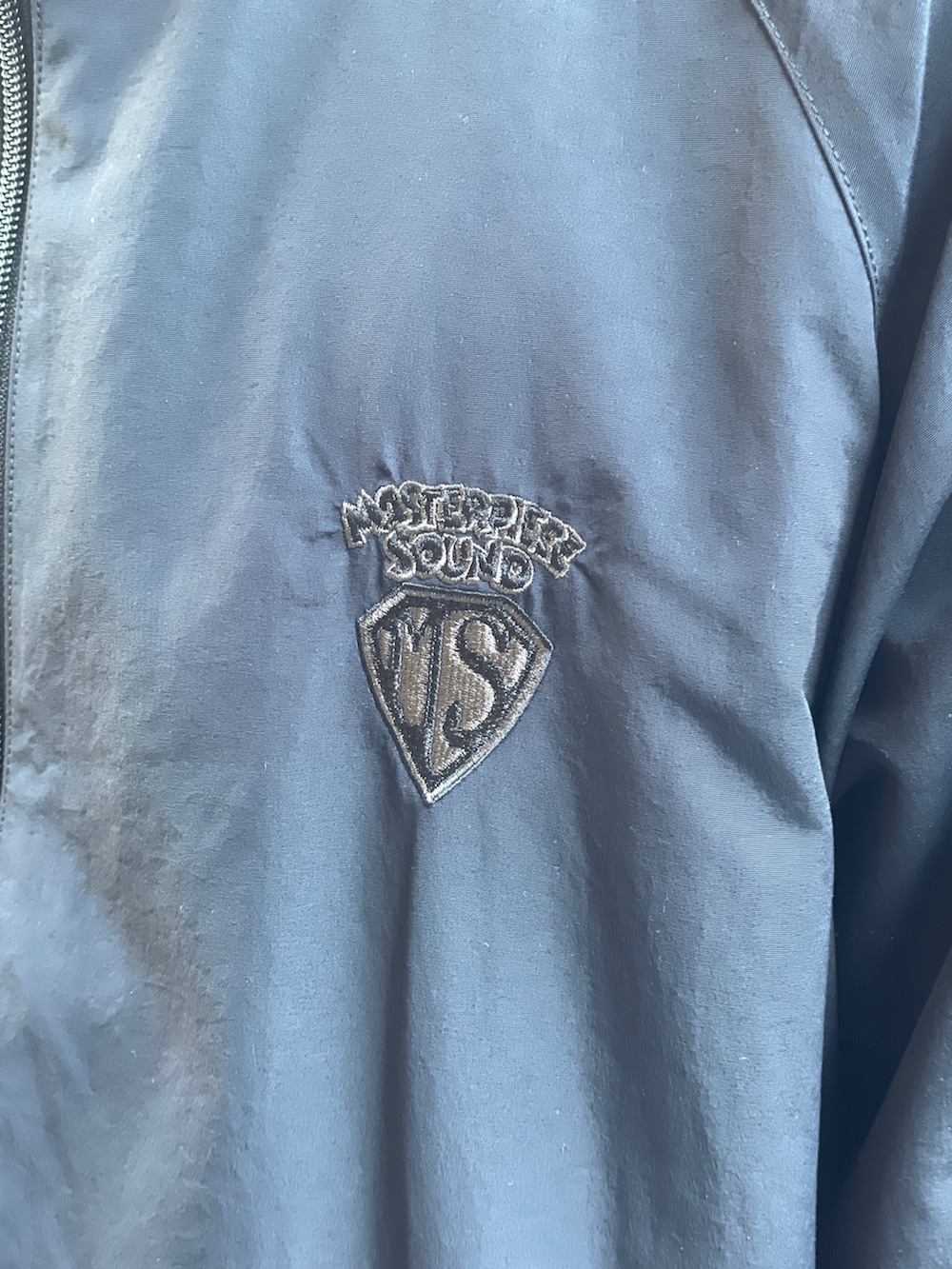 ブラック系のブルゾン、ブルー系のスウェットパンツ、ブラック系のサンダルを着用したメンズの冬コーディネートの5枚目の写真