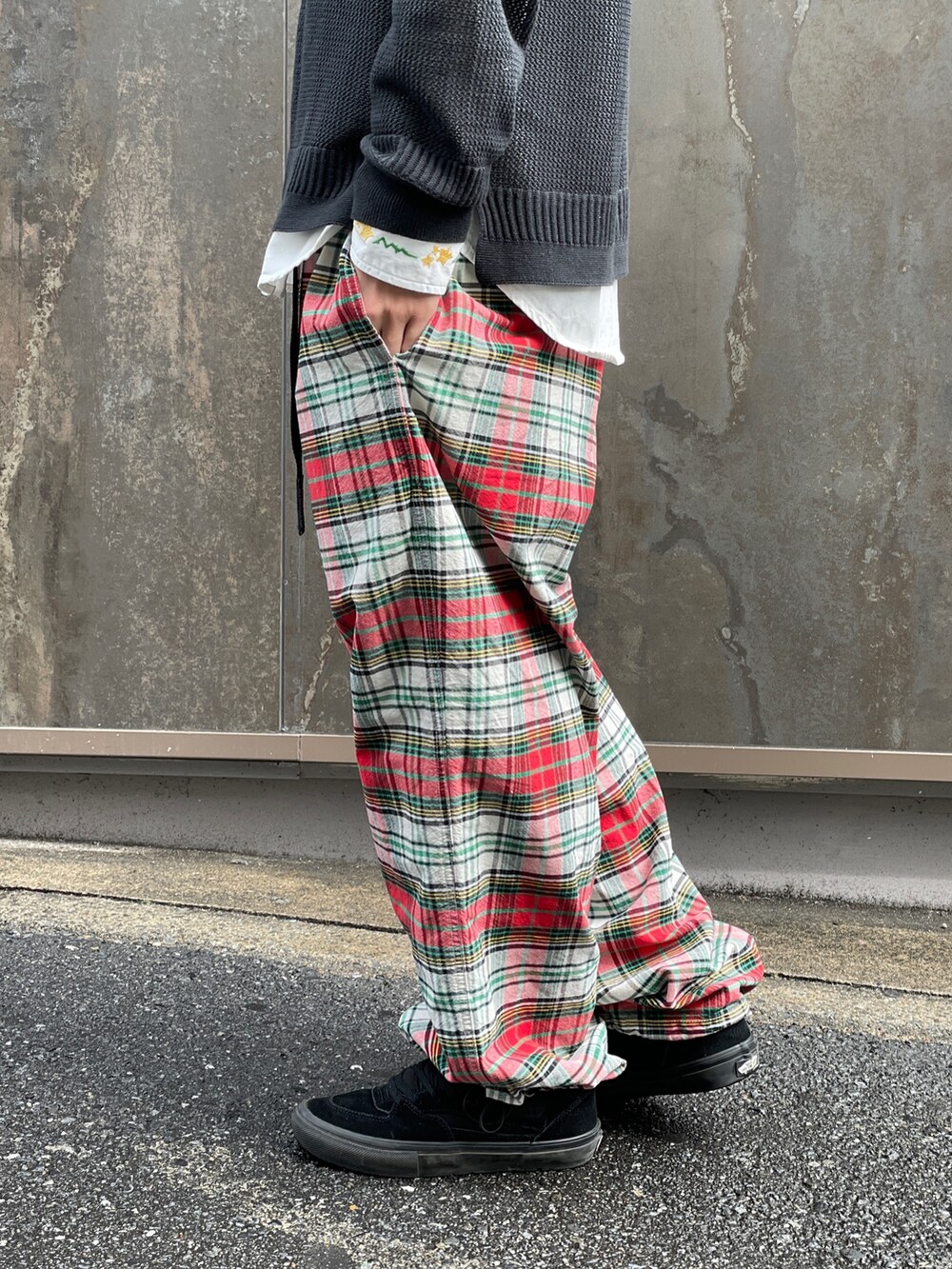 ブラック系のニット/セーター、レッド系のその他パンツ、ホワイト系のシャツ/ブラウスを着用したメンズの春コーディネートの7枚目の写真