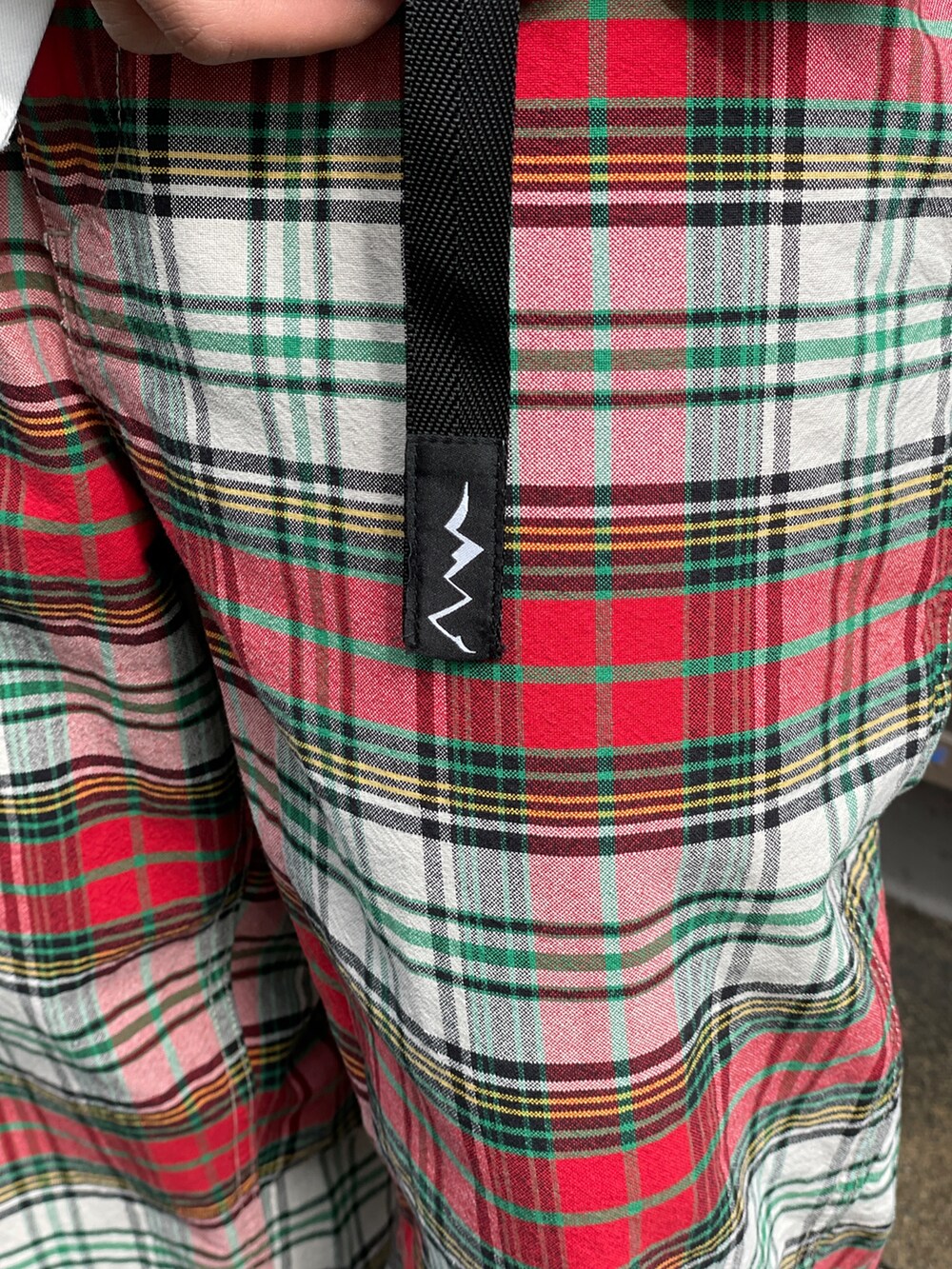 ブラック系のニット/セーター、レッド系のその他パンツ、ホワイト系のシャツ/ブラウスを着用したメンズの春コーディネートの9枚目の写真