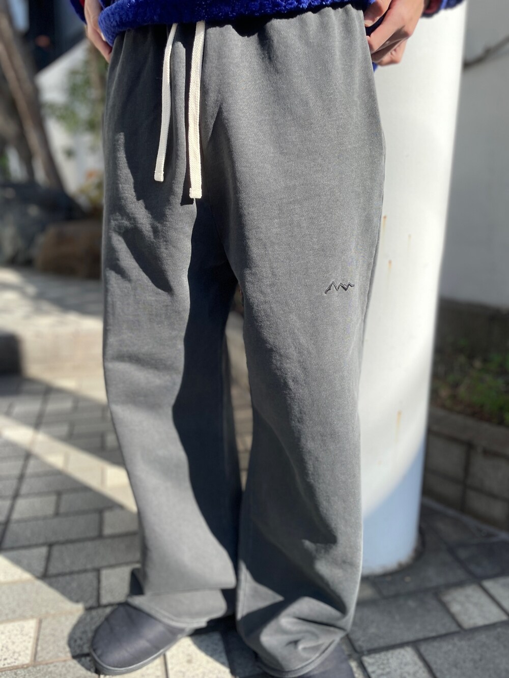 ブルー系のその他アウター、ブラック系のスウェットパンツ、ブラック系のサンダルを着用したメンズの冬コーディネートの6枚目の写真