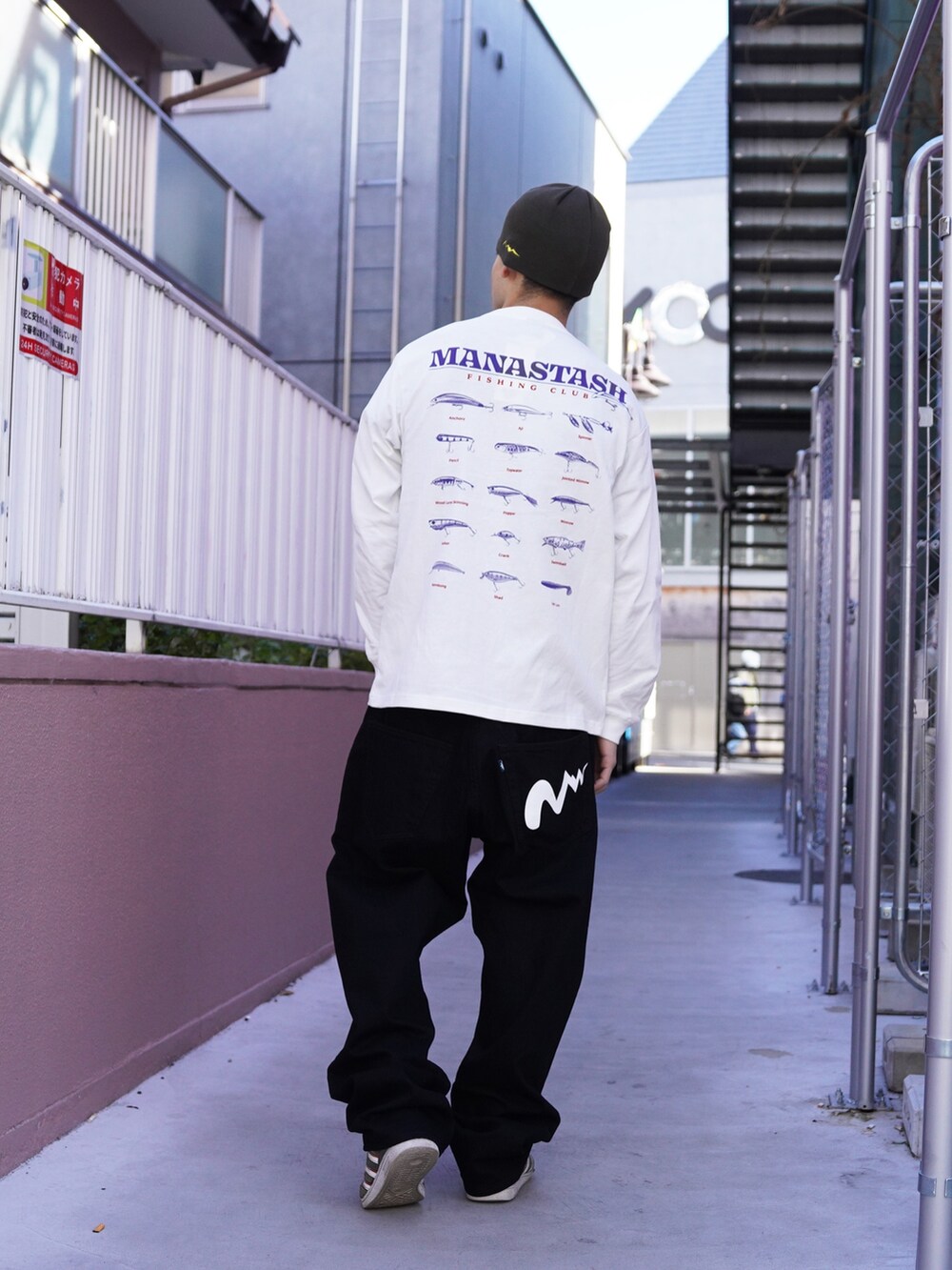 ホワイト系のTシャツ/カットソー、ブラック系のデニムパンツ、グリーン系のニットキャップ/ビーニーを着用したメンズの冬コーディネートの3枚目の写真