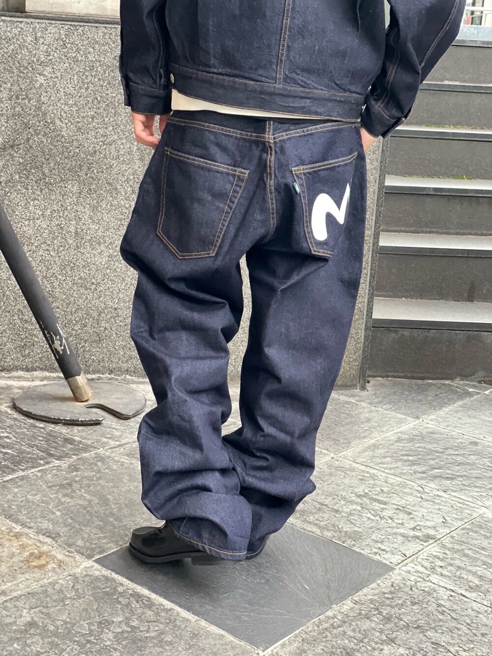 ホワイト系のパーカー、ブルー系のデニムパンツを着用したメンズの冬コーディネートの7枚目の写真