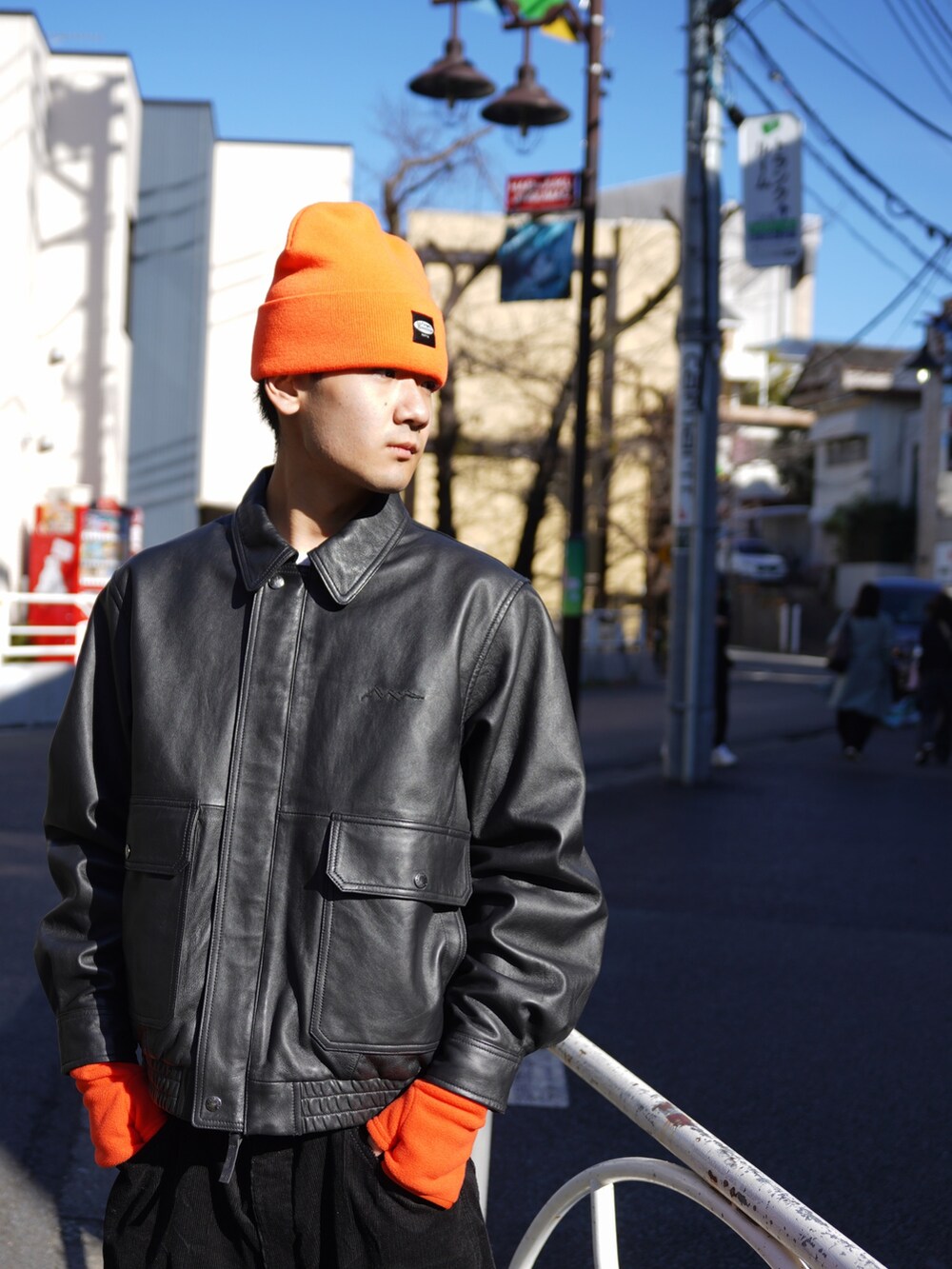 ブラック系のブルゾン、ブラック系のその他パンツ、オレンジ系の手袋を着用したメンズの冬コーディネートの4枚目の写真