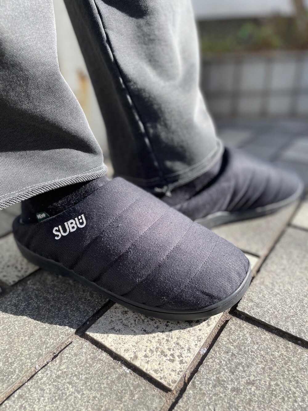 ブルー系のその他アウター、ブラック系のスウェットパンツ、ブラック系のサンダルを着用したメンズの冬コーディネートの9枚目の写真