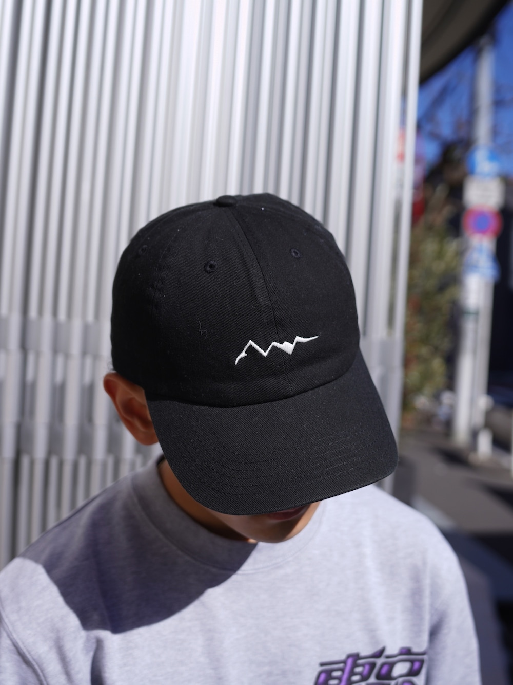 グレー系のスウェット、ブルー系のデニムパンツ、ブラック系のキャップを着用したメンズの冬コーディネートの10枚目の写真