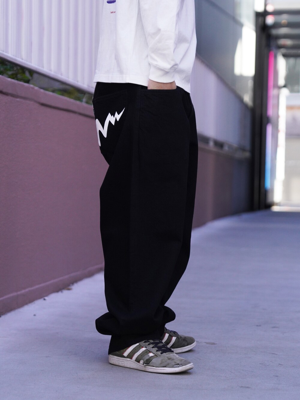 ホワイト系のTシャツ/カットソー、ブラック系のデニムパンツ、グリーン系のニットキャップ/ビーニーを着用したメンズの冬コーディネートの6枚目の写真