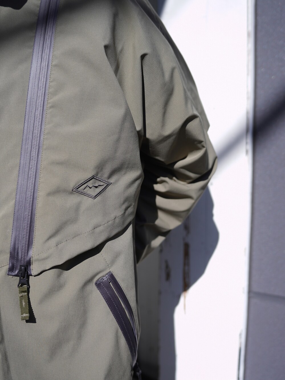 グリーン系のブルゾン、ベージュ系のその他パンツ、ホワイト系のハットを着用したメンズの冬コーディネートの5枚目の写真