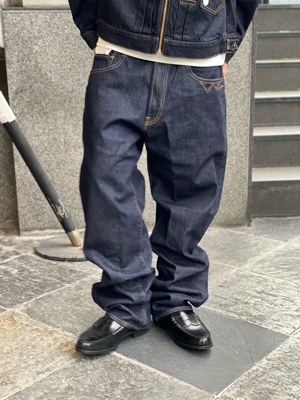 ホワイト系のパーカー、ブルー系のデニムパンツを着用したメンズの冬コーディネートの5枚目の写真