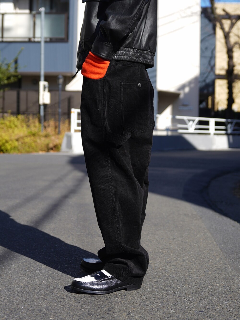 ブラック系のブルゾン、ブラック系のその他パンツ、オレンジ系の手袋を着用したメンズの冬コーディネートの6枚目の写真