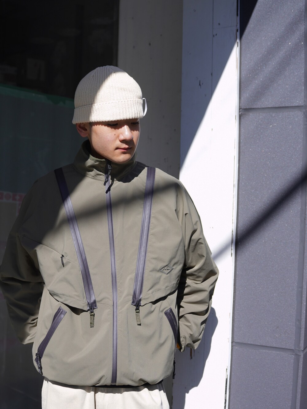 グリーン系のブルゾン、ベージュ系のその他パンツ、ホワイト系のハットを着用したメンズの冬コーディネートの4枚目の写真