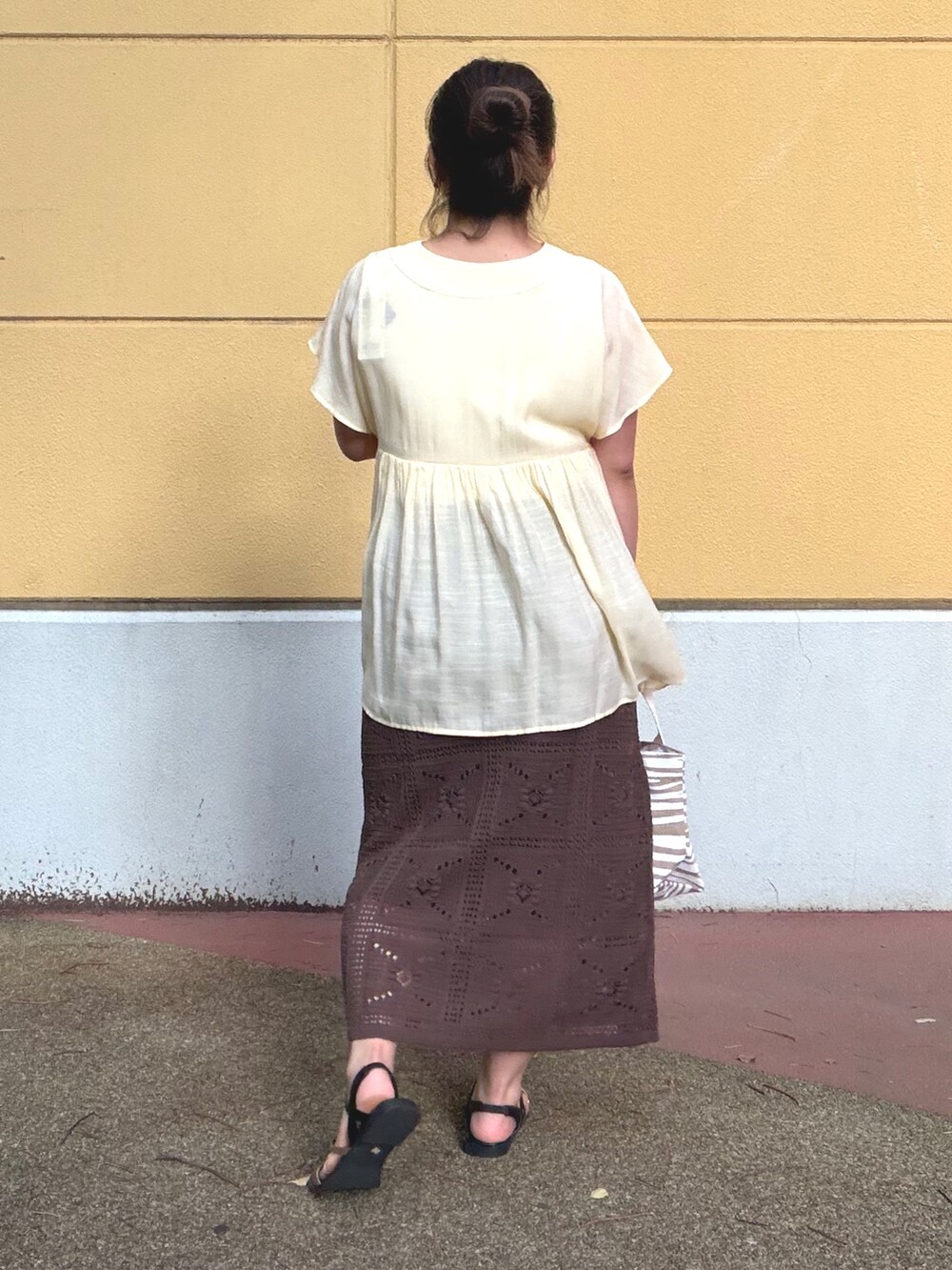 ホワイト系のタンクトップ、イエロー系のシャツ/ブラウス、ブラウン系のスカートを着用したレディースの夏コーディネートの6枚目の写真