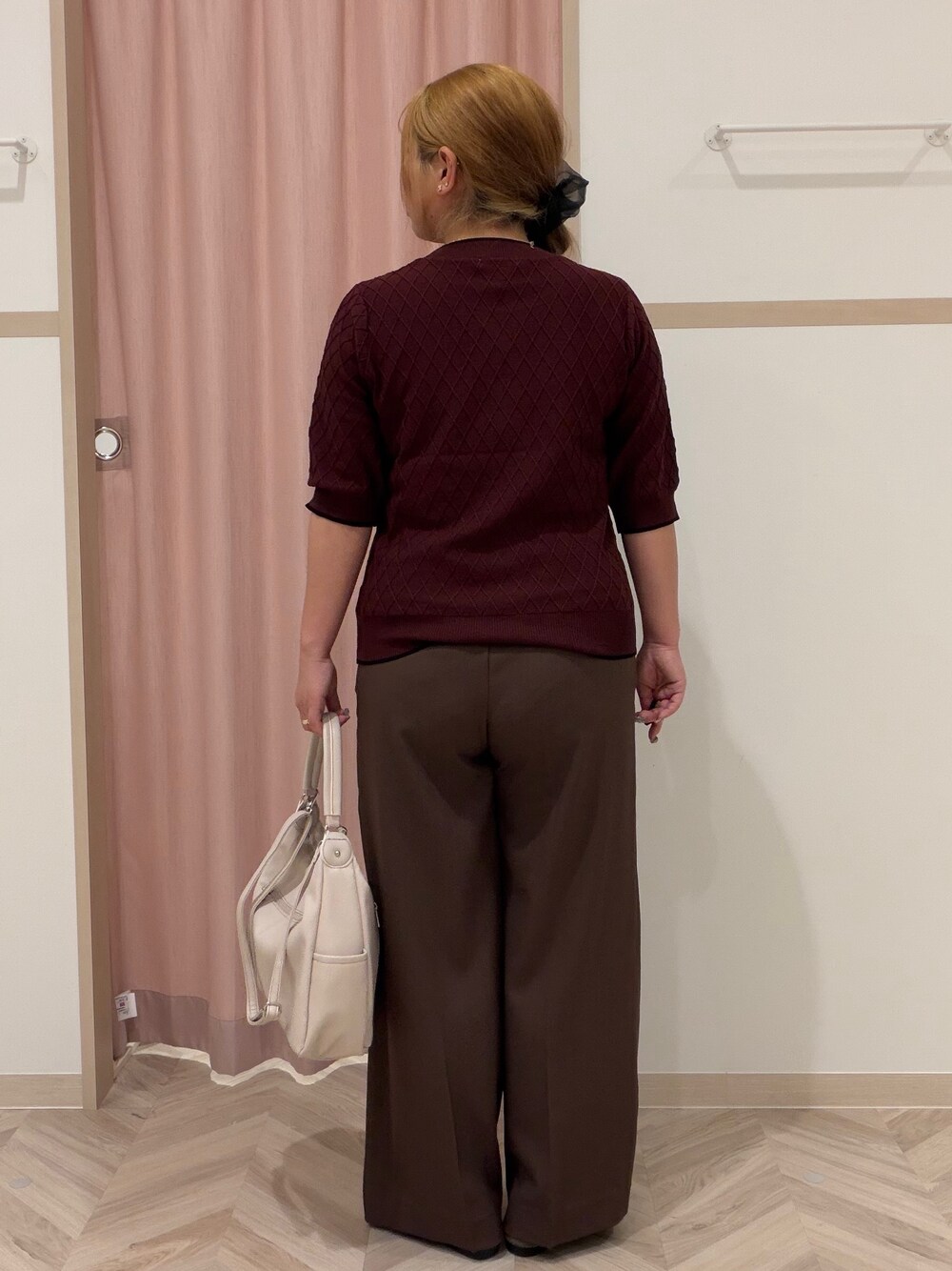 レッド系のニット/セーター、ブラウン系のその他パンツ、ブラック系のその他シューズを着用したレディースの夏コーディネートの5枚目の写真