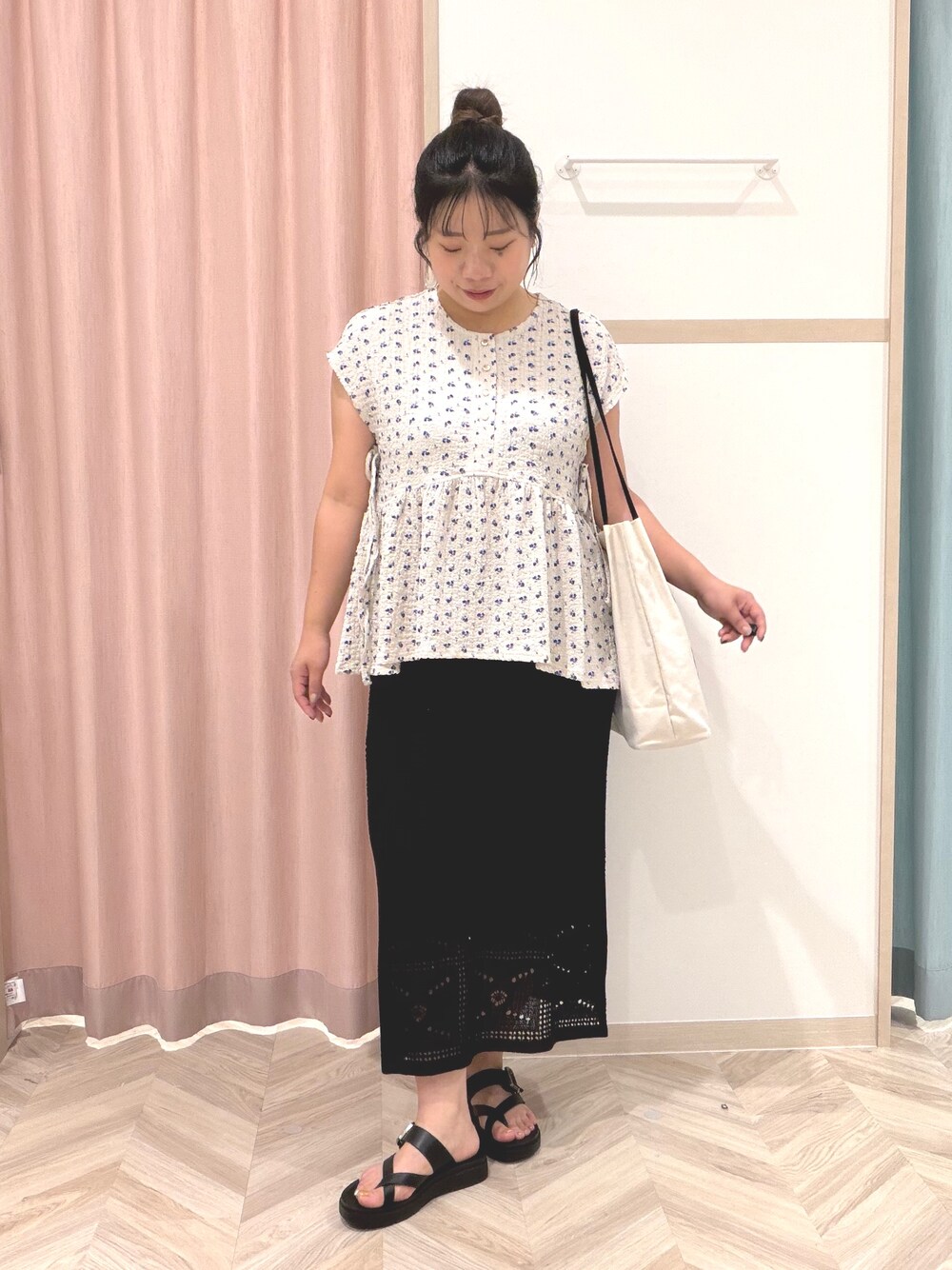 グレー系のTシャツ/カットソー、ブラック系のスカート、ホワイト系のトートバッグを着用したレディースの夏コーディネートの2枚目の写真