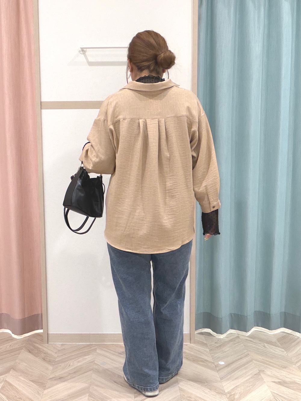 ブラック系のTシャツ/カットソー、ベージュ系のシャツ/ブラウス、ブルー系のデニムパンツを着用したレディースの秋コーディネートの5枚目の写真