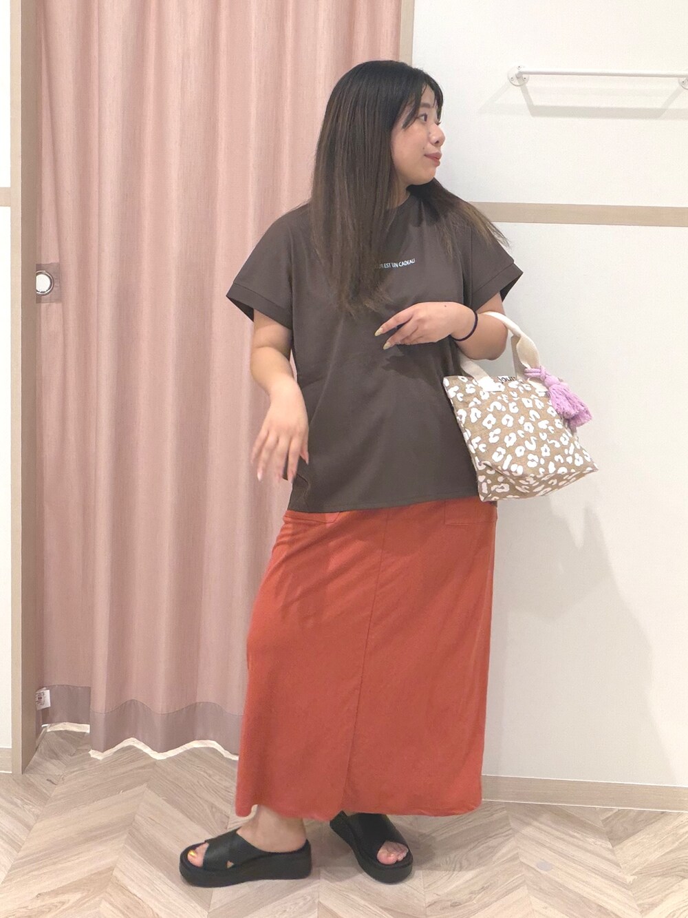 ブラウン系のTシャツ/カットソー、レッド系のスカート、ブラック系のサンダルを着用したレディースの夏コーディネートの2枚目の写真