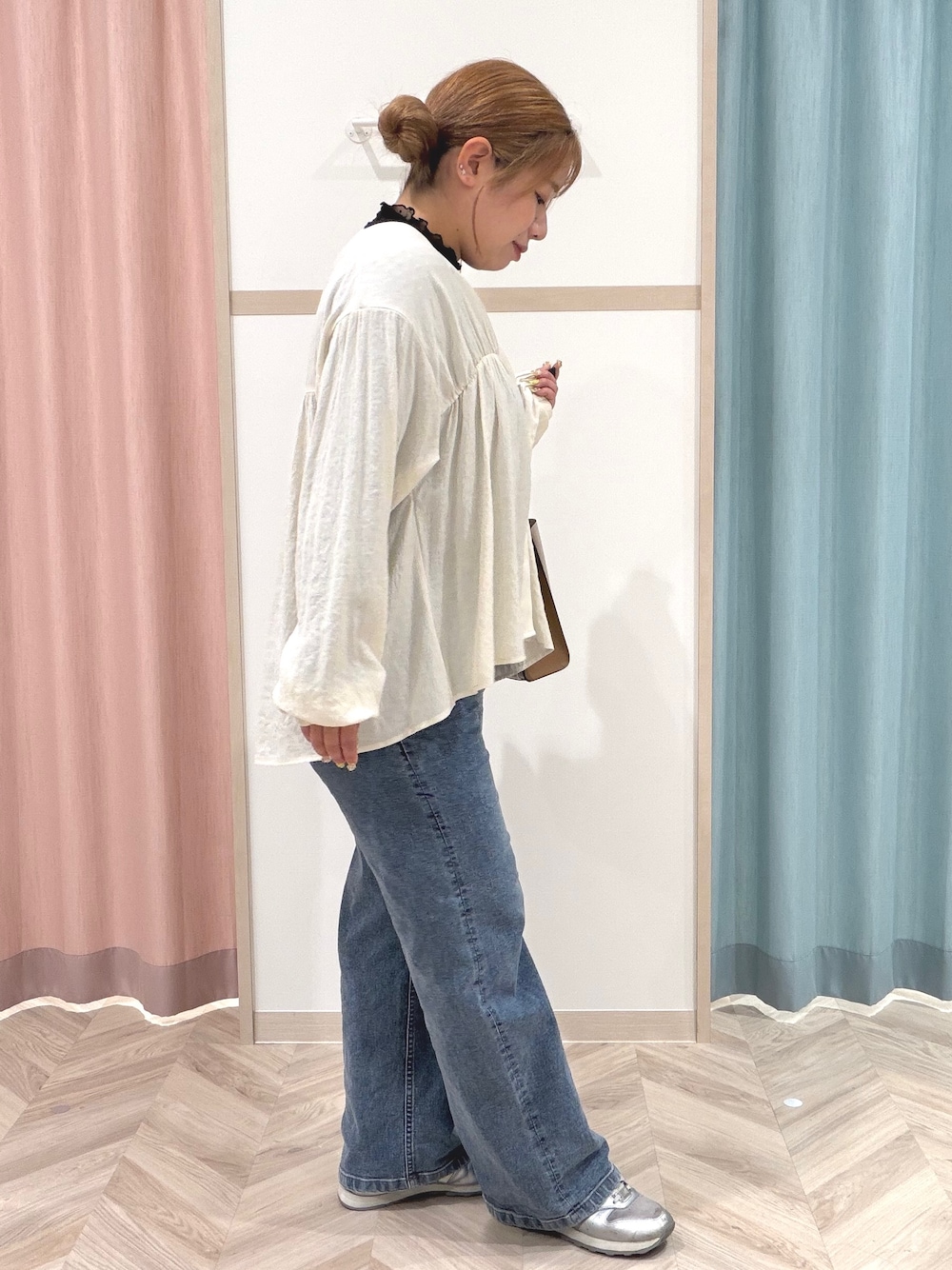 ブラック系のTシャツ/カットソー、ホワイト系のカーディガン/ボレロ、ブルー系のデニムパンツを着用したレディースの秋コーディネートの3枚目の写真