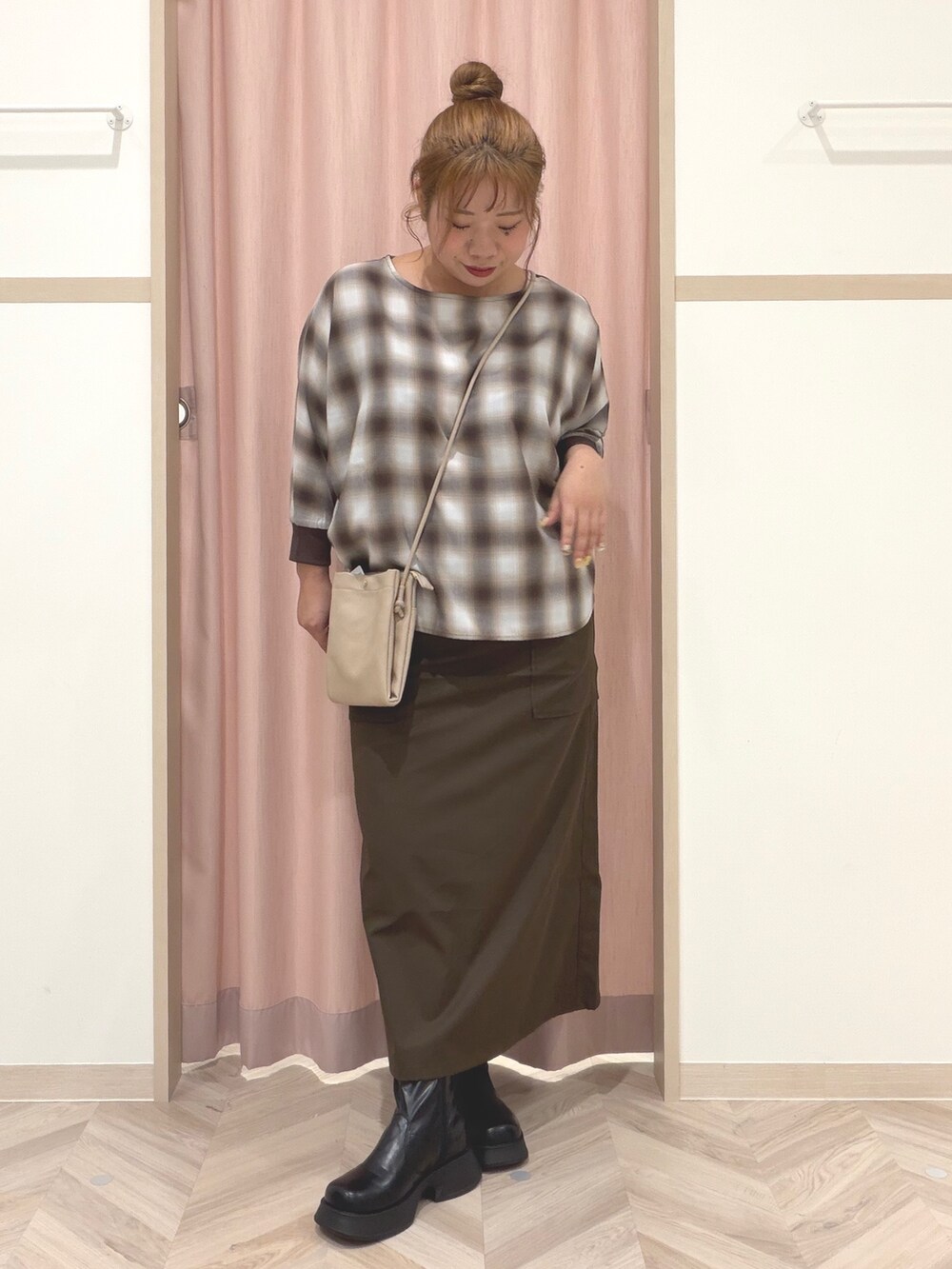ベージュ系のシャツ/ブラウス、ブラック系のブーツ、ベージュ系のショルダーバッグを着用したレディースの秋コーディネートの2枚目の写真