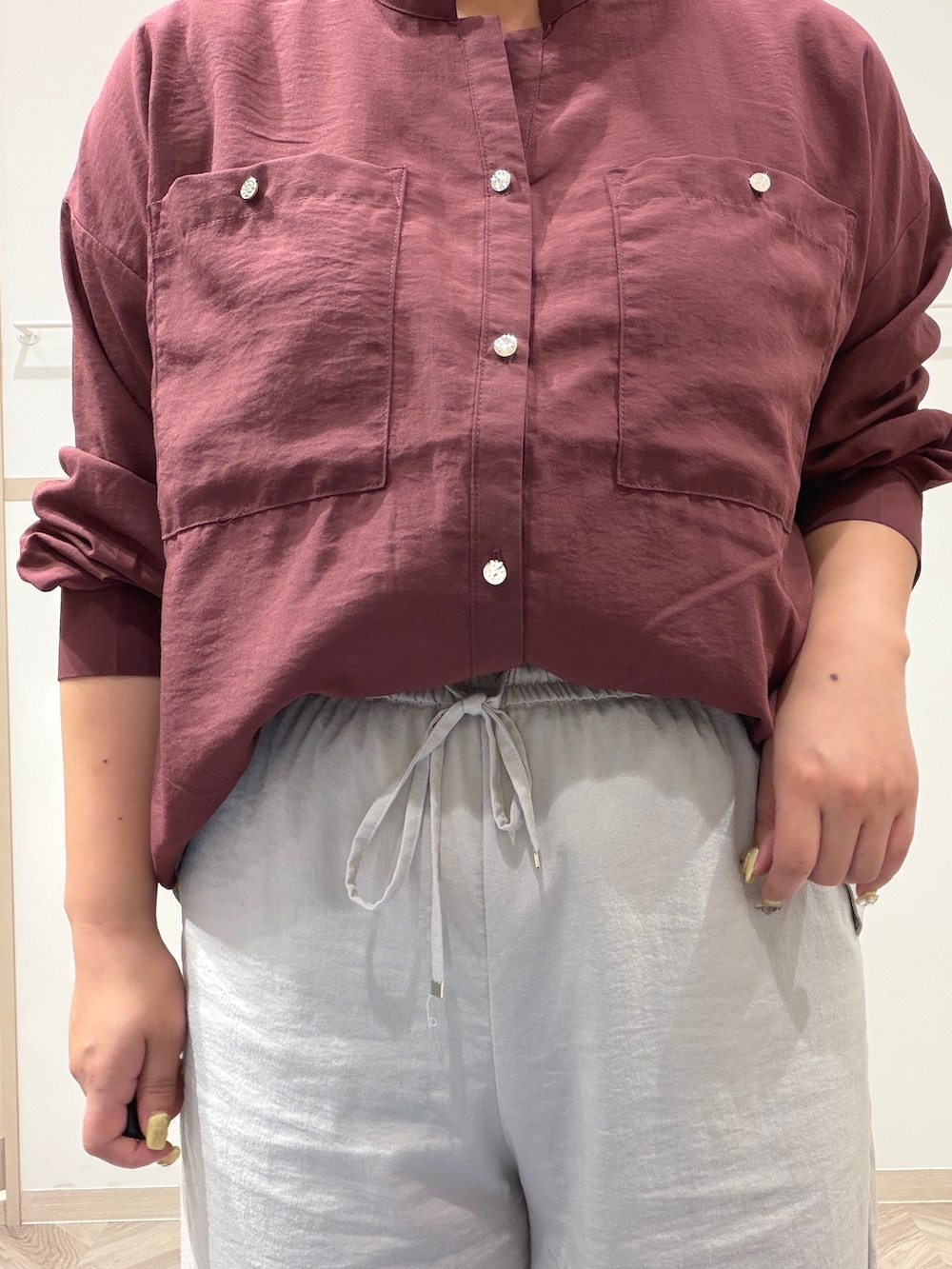 レッド系のシャツ/ブラウス、ベージュ系のその他パンツ、ブラック系のショルダーバッグを着用したレディースの秋コーディネートの8枚目の写真