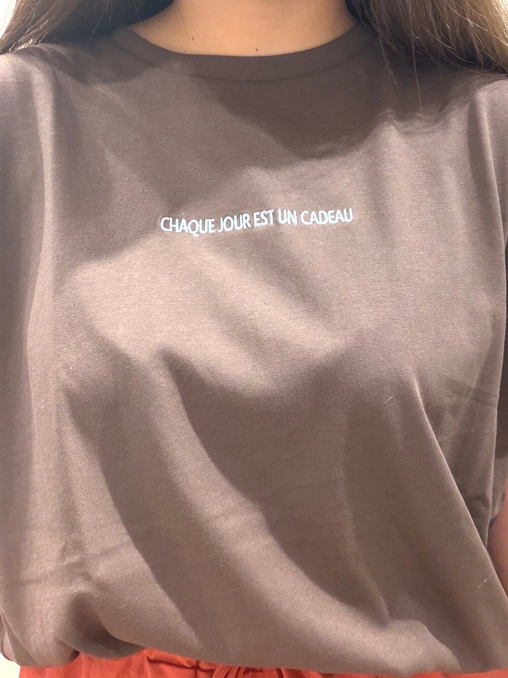 ブラウン系のTシャツ/カットソー、レッド系のスカート、ブラック系のサンダルを着用したレディースの夏コーディネートの9枚目の写真