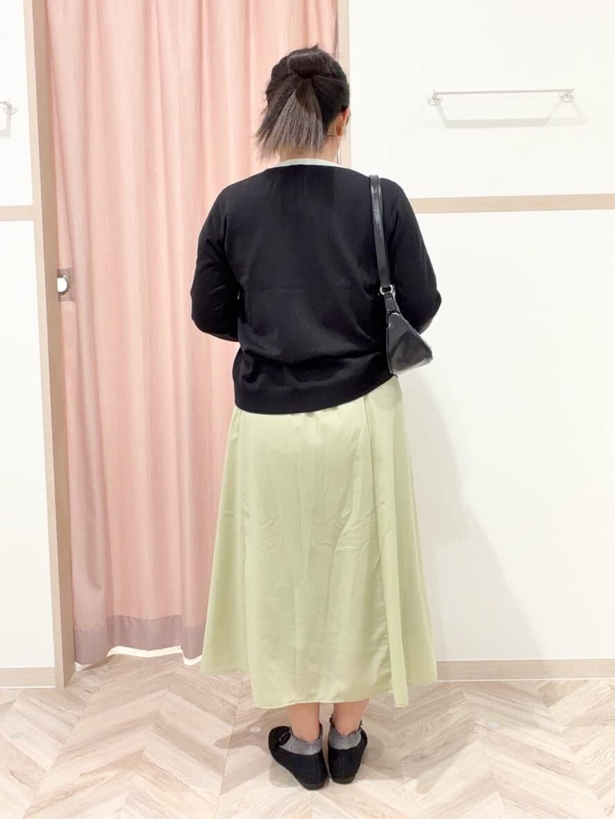 ブラック系のニット/セーター、ブラック系のカーディガン/ボレロ、グリーン系のスカートを着用したレディースの冬コーディネートの3枚目の写真