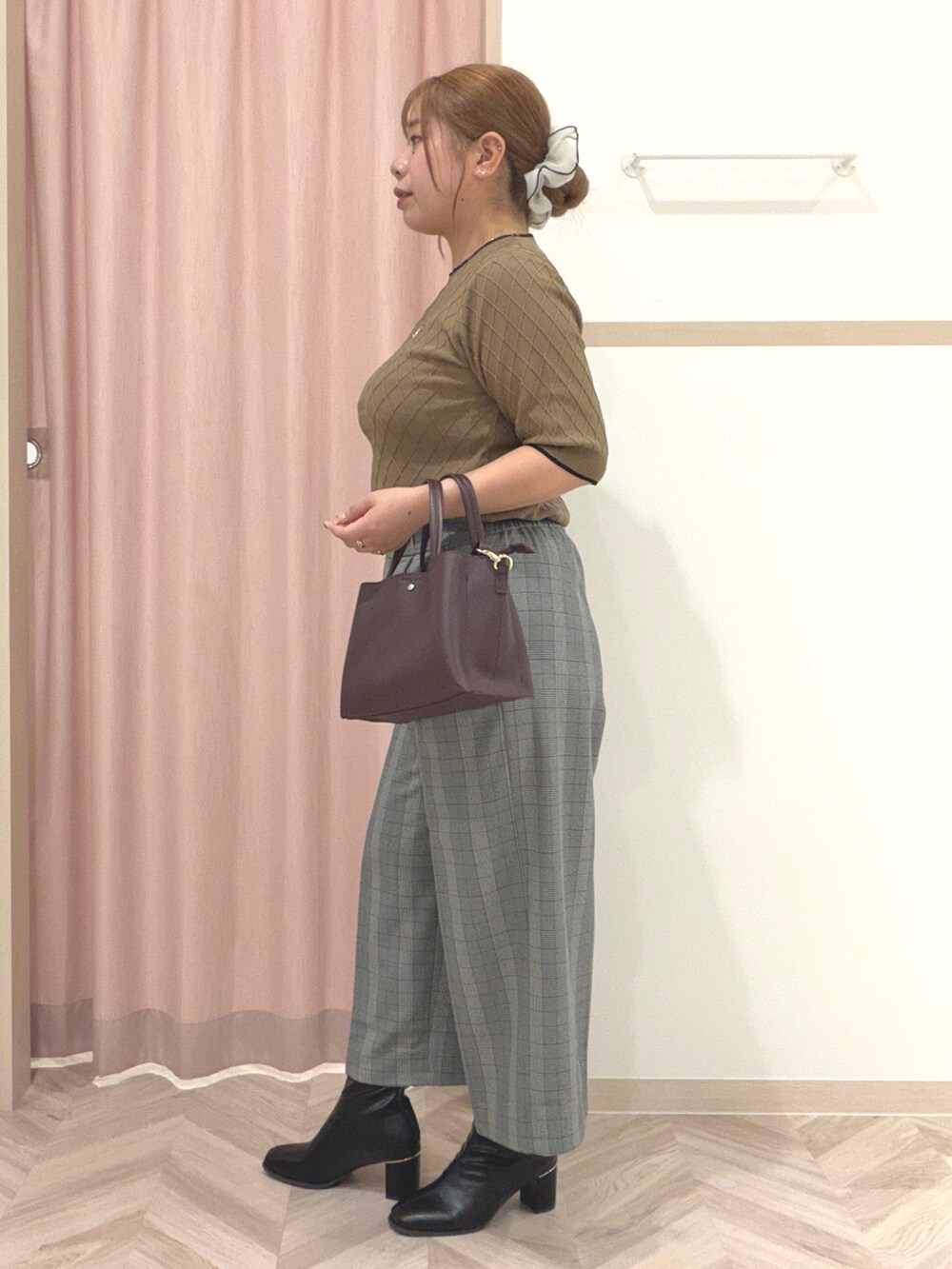 ベージュ系のニット/セーター、グレー系のその他パンツ、ブラック系のブーツを着用したレディースの秋コーディネートの6枚目の写真