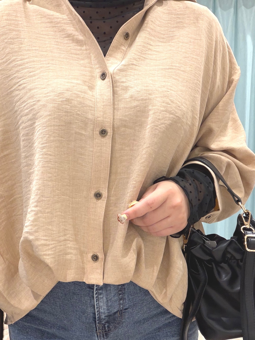 ブラック系のTシャツ/カットソー、ベージュ系のシャツ/ブラウス、ブルー系のデニムパンツを着用したレディースの秋コーディネートの7枚目の写真