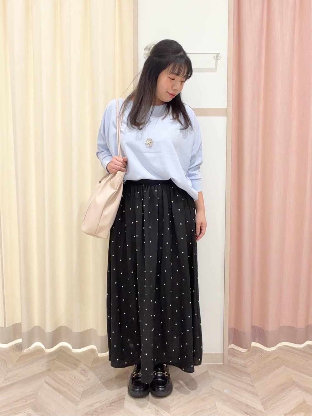 ブルー系のシャツ/ブラウス、ブラック系のスカート、ホワイト系のトートバッグを着用したレディースの春コーディネートの2枚目の写真