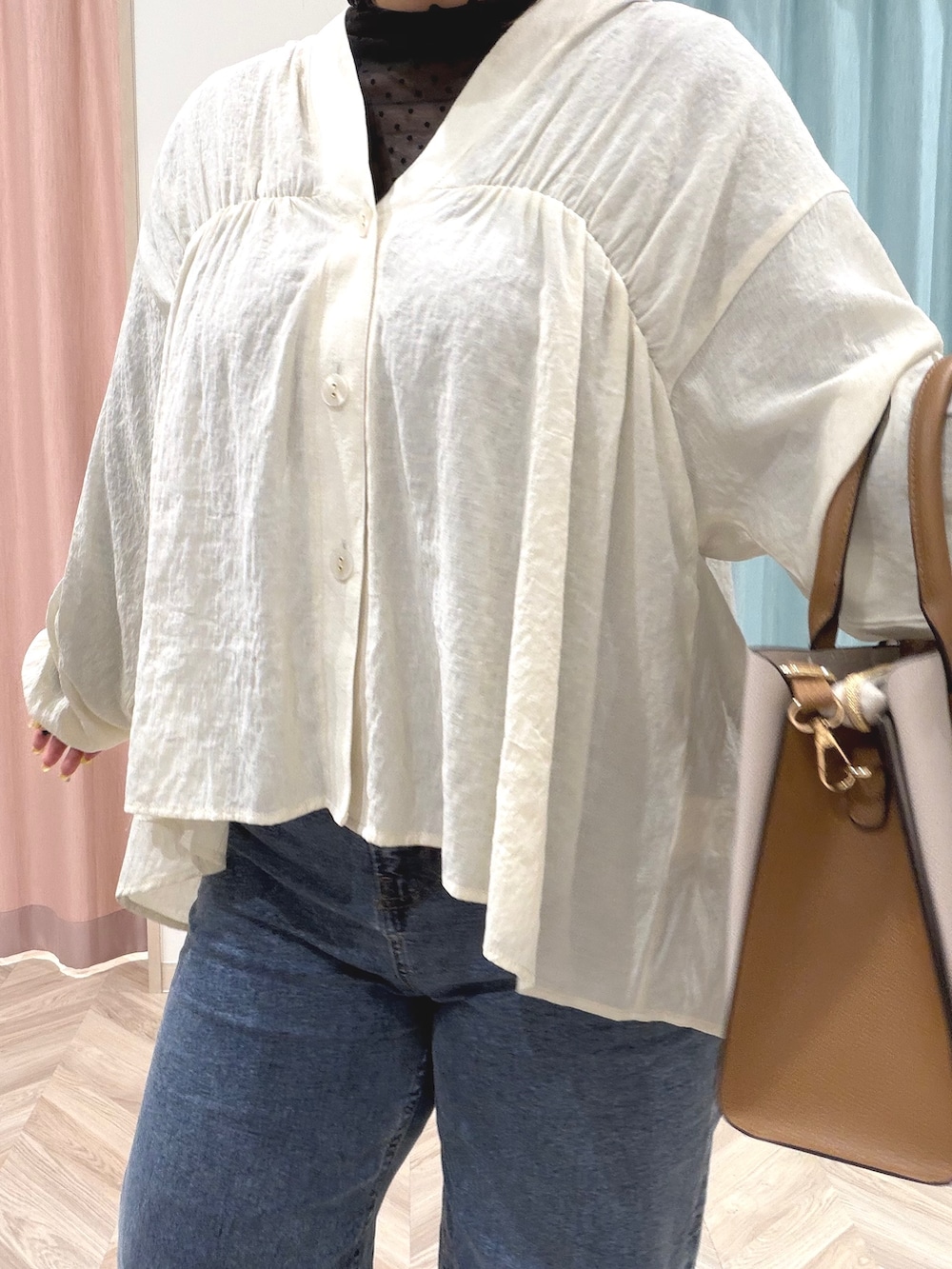 ブラック系のTシャツ/カットソー、ホワイト系のカーディガン/ボレロ、ブルー系のデニムパンツを着用したレディースの秋コーディネートの7枚目の写真