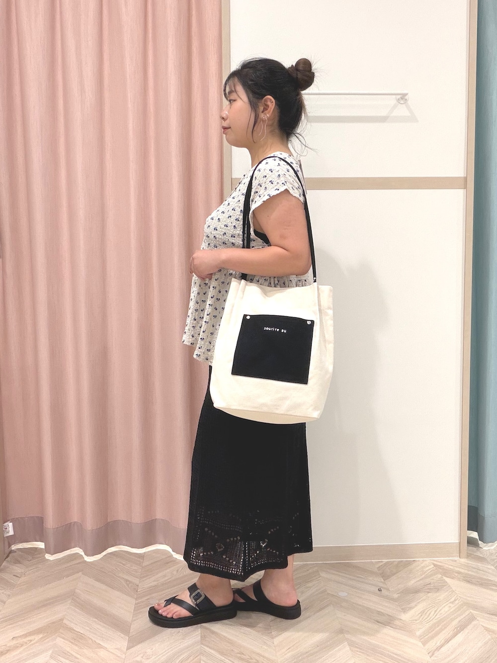 グレー系のTシャツ/カットソー、ブラック系のスカート、ホワイト系のトートバッグを着用したレディースの夏コーディネートの5枚目の写真