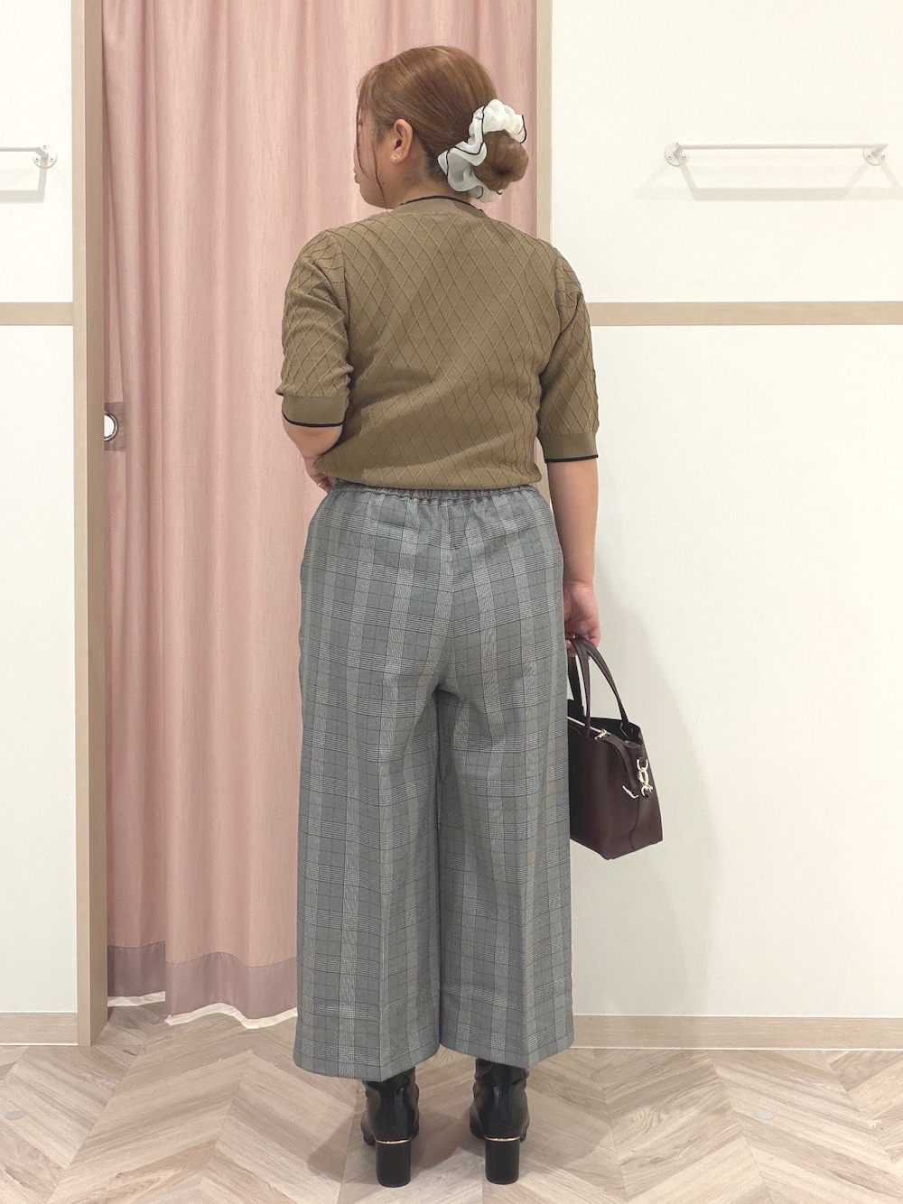 ベージュ系のニット/セーター、グレー系のその他パンツ、ブラック系のブーツを着用したレディースの秋コーディネートの7枚目の写真