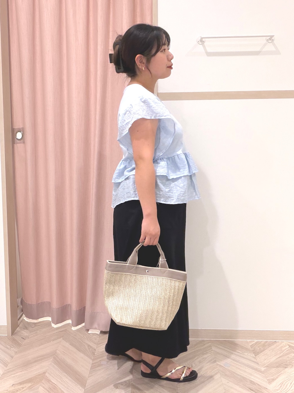 ブルー系のTシャツ/カットソー、ブラック系のスカート、ベージュ系のトートバッグを着用したレディースの夏コーディネートの3枚目の写真