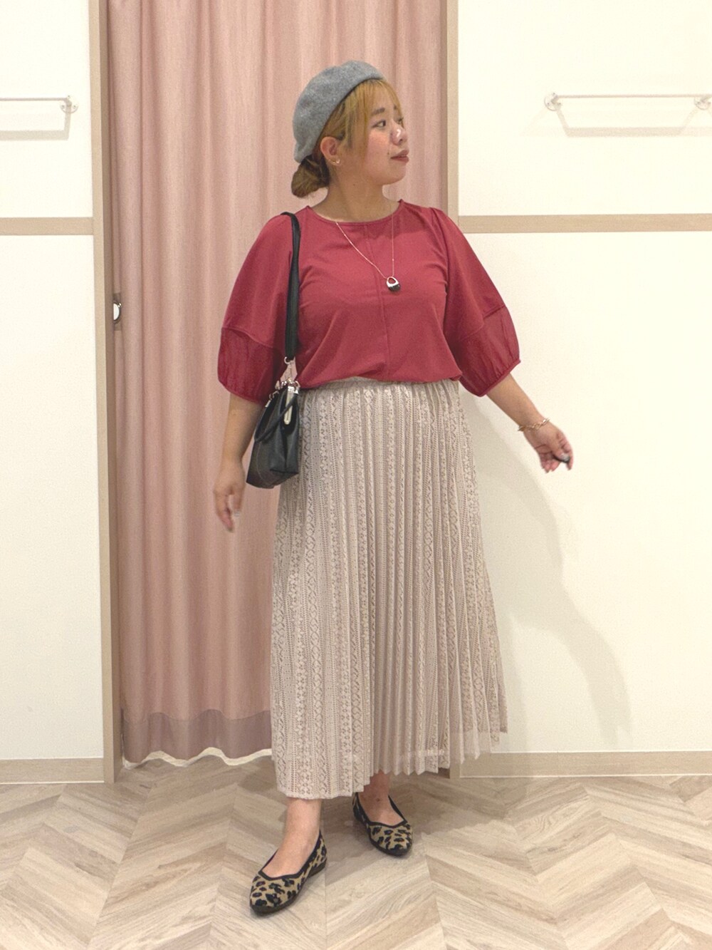 レッド系のTシャツ/カットソー、ベージュ系のスカート、ブラウン系のパンプスを着用したレディースの夏コーディネートの2枚目の写真