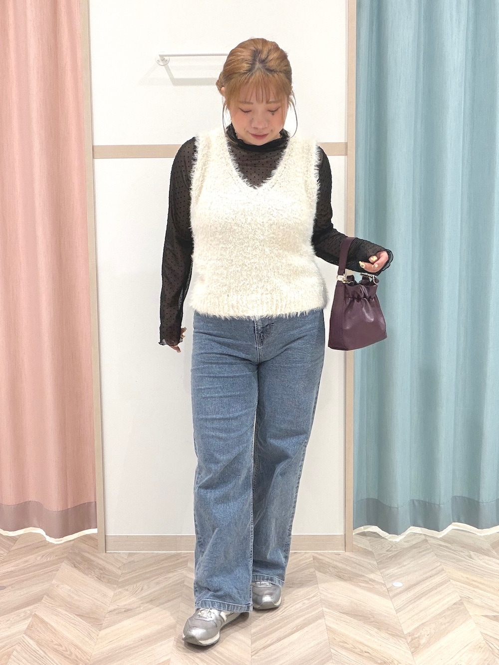 ブラック系のTシャツ/カットソー、ホワイト系のベスト、ブルー系のデニムパンツを着用したレディースの秋コーディネートの2枚目の写真