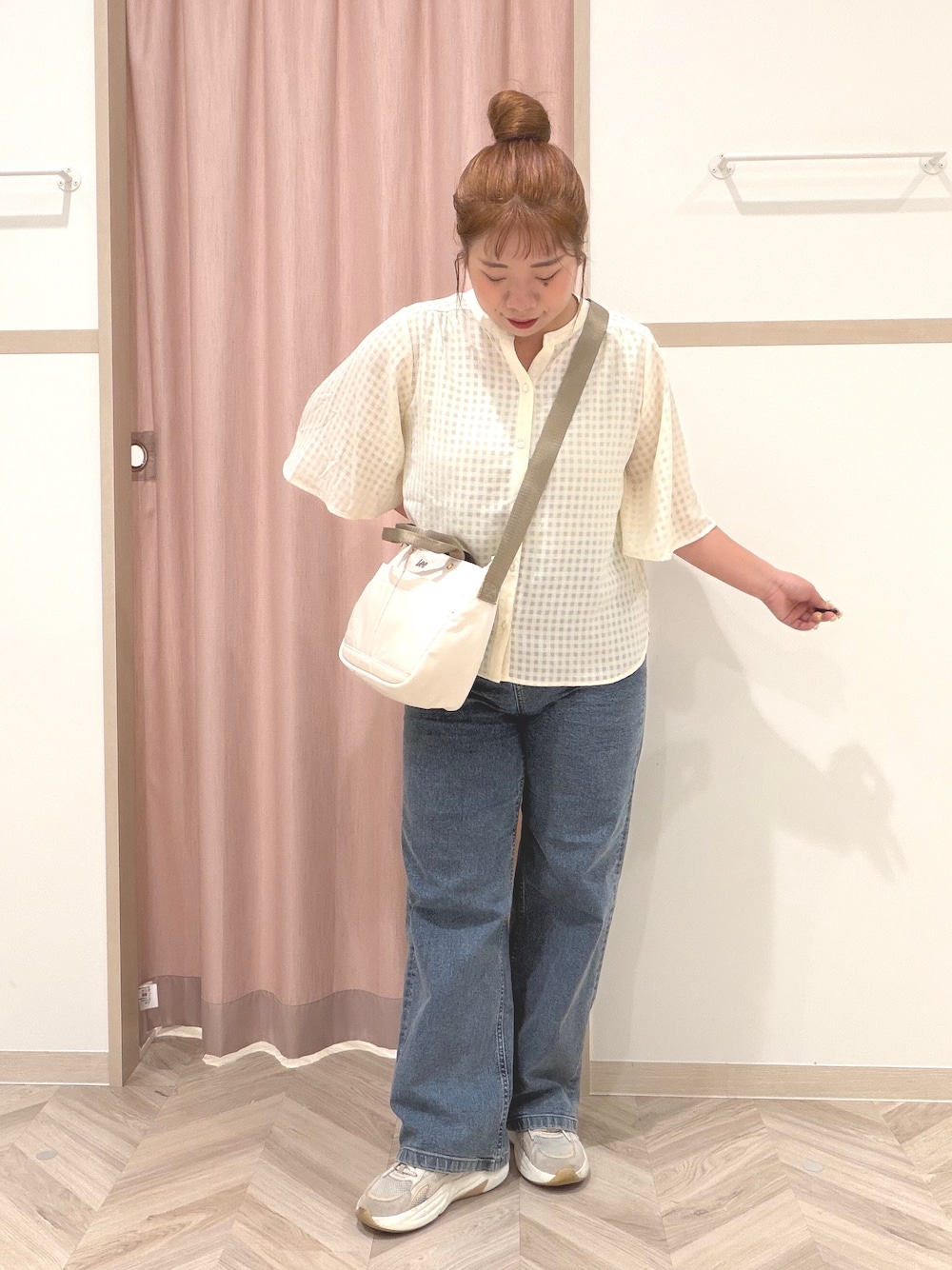 ゴールド系のタンクトップ、ホワイト系のシャツ/ブラウス、ブルー系のデニムパンツを着用したレディースの夏コーディネートの3枚目の写真