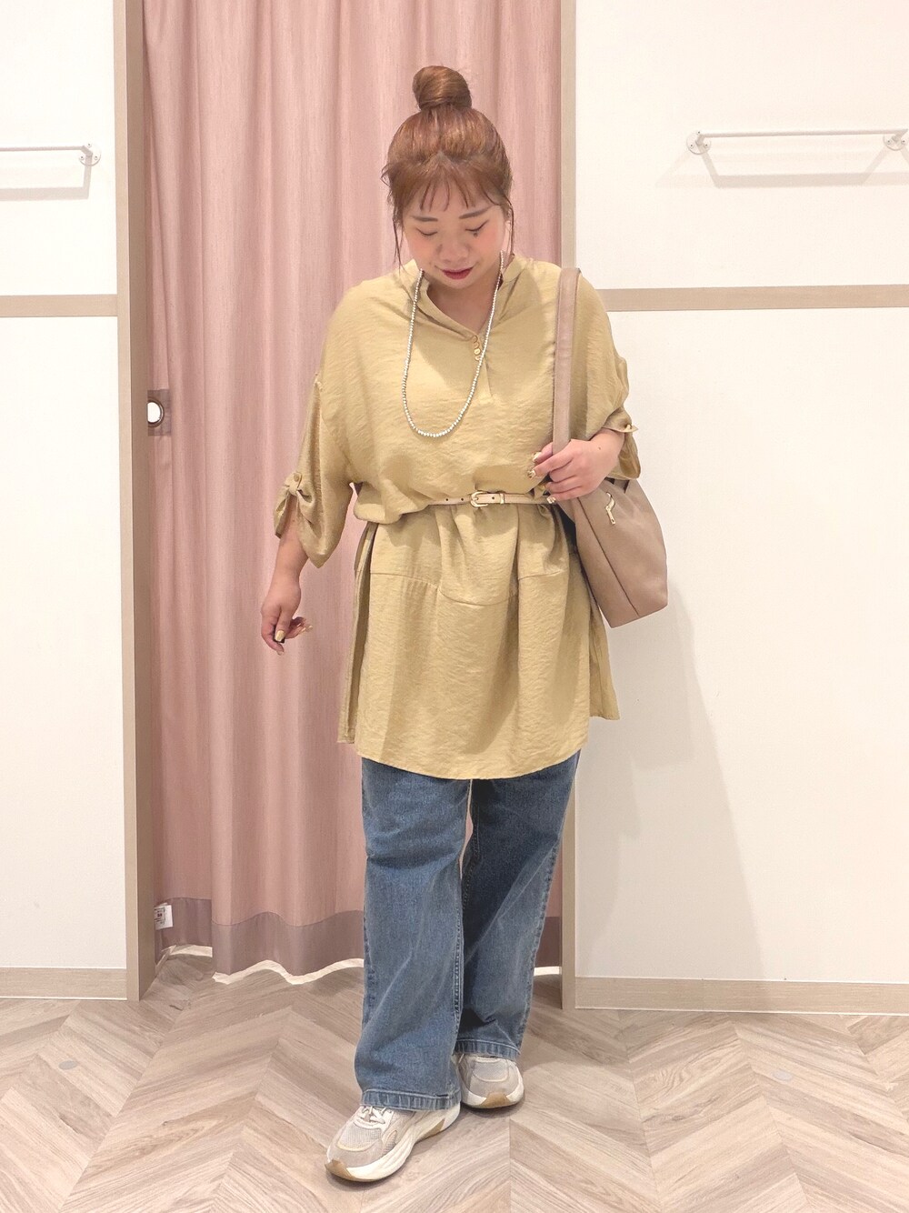 イエロー系のワンピース、ブルー系のデニムパンツ、ベージュ系のショルダーバッグを着用したレディースの夏コーディネートの2枚目の写真